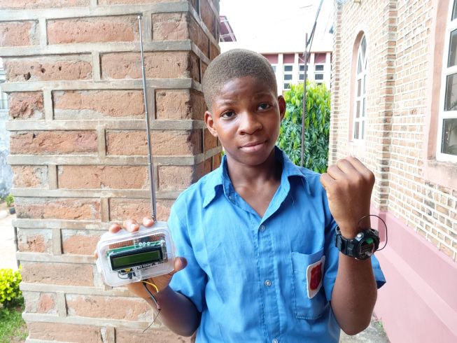 A boy holds up two parts of a tech device