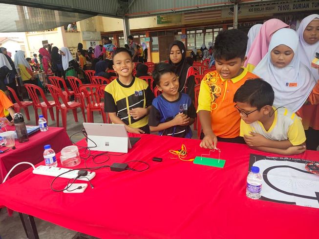 Pupils displaying their micro:bit creations at a STEM carnival, following a session with mentors