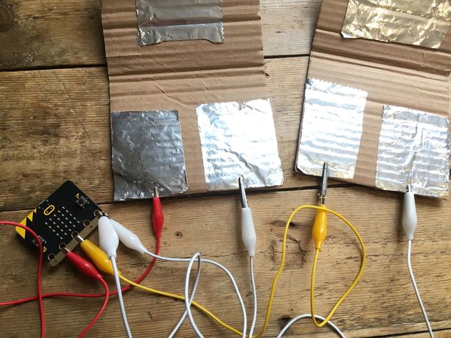Dois "botões" (interruptores) caseiros sensíveis à pressão conectados aos pinos do micro:bit