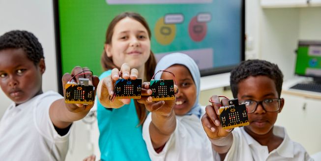 Primary school children holding micro:bits