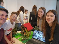 Students gather around the protection from weather disasters prototype.
