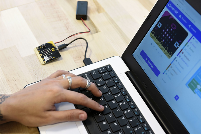 student working on a laptop with a micro:bit