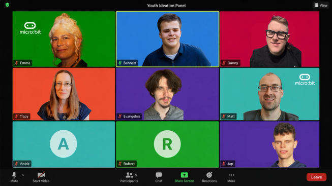 Screenshot-style image of a virtual Youth Ideation Panel meeting in gallery view. Nine participant tiles are shown in a 3 by 3 grid, with Emma, Bennett, Danny, Tracy, Evangeloz, Matt and Jop shown on camera, and Aniek and Robert represented by initial avatars. The tiles use bright micro:bit brand colours, with white micro:bit logos on Emma and Matt’s backgrounds. Bennett’s tile is highlighted to show he is speaking, while the other participants appear muted. The Zoom-style interface includes the meeting title “Youth Ideation Panel” and controls for mute, video, participants, chat, share screen, reactions and leave.