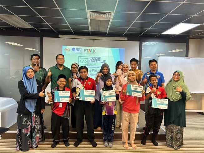 Dr Rina stands with a group of children proudly showing off their workshop completion certificates, with their student mentors standing behind them