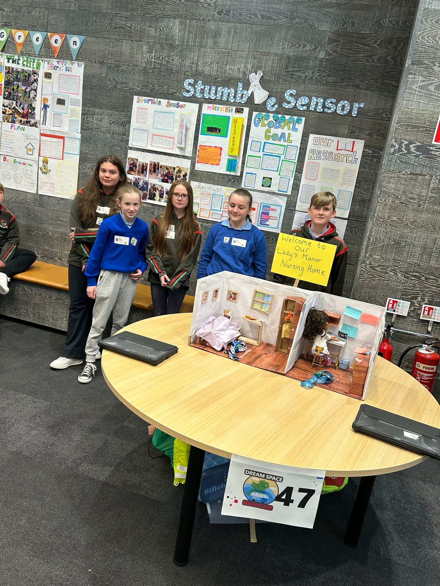 Students stand next to a prototype of the stumble sensor.