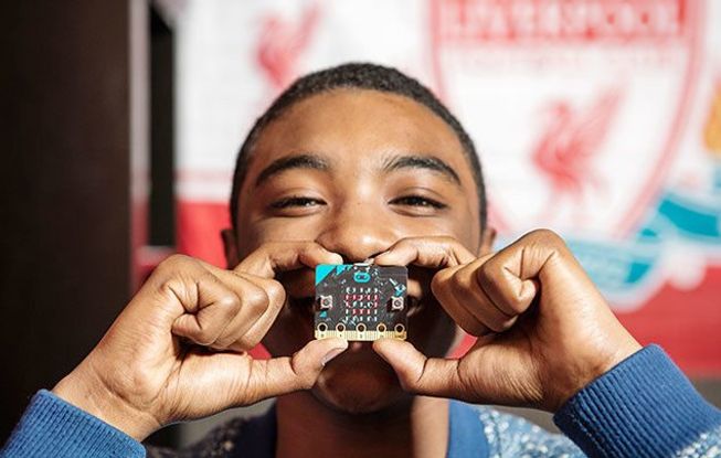 Boy holding micro:bit up to face