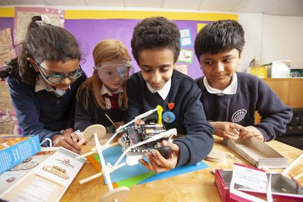 Four children working with Microbit and crafts