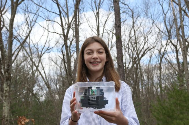 Young girl holding her micro:bit invention