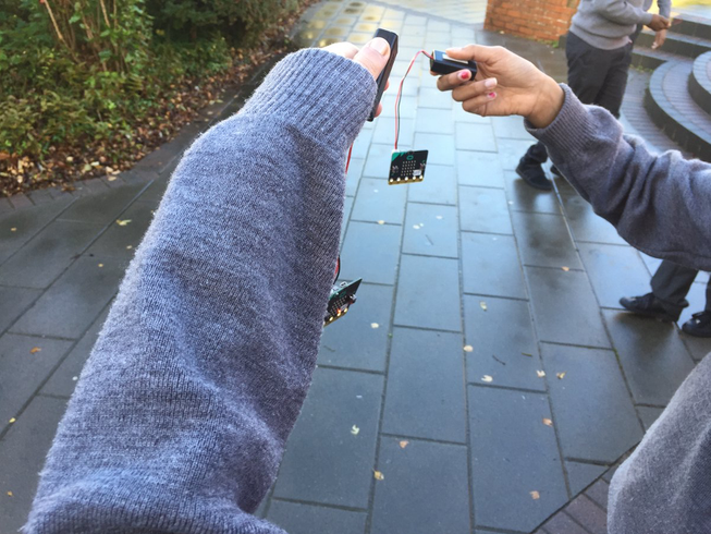Students hands holding micro:bits outside