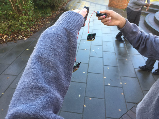 Students hands holding micro:bits outside