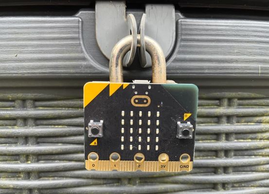 a micro:bit attached to a padlock securing a box