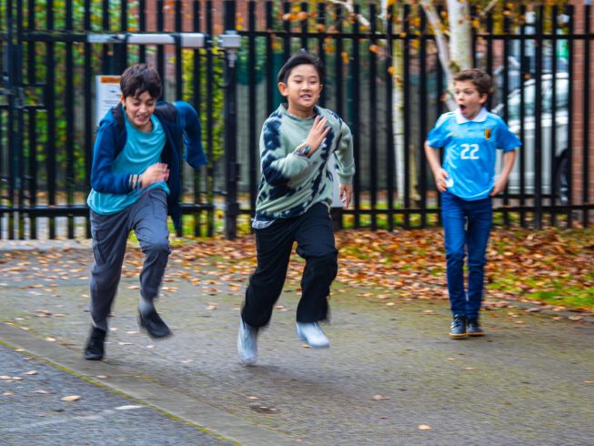 Students running outdoors during a race, with motion blur capturing speed and energy.