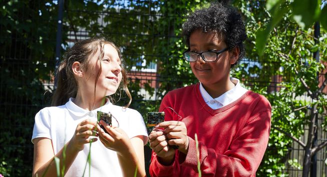 Two students using the micro:bit outdoors