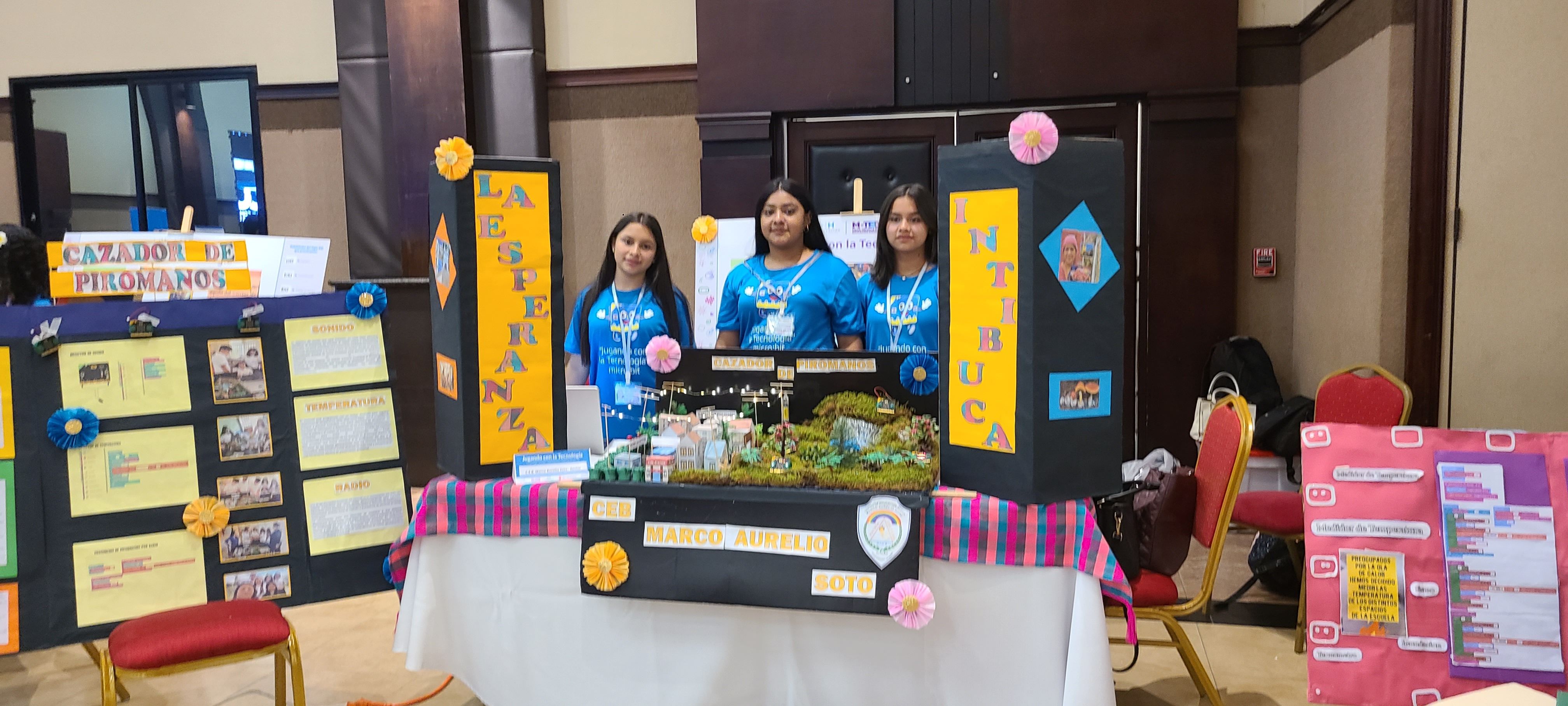 Students pose with their presentation poster and a prototype of their project.