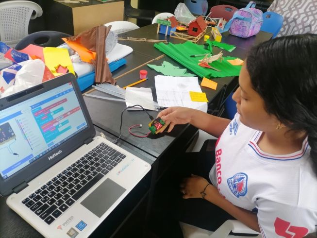 A student in Honduras codes the micro:bit for her project, 'The house that listens to the earth', as part of Tinkering with Tech