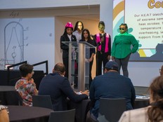 Students present the Tech 8 project behind a lectern.