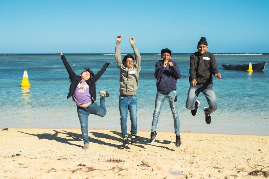 Children jumping in front of the ocean