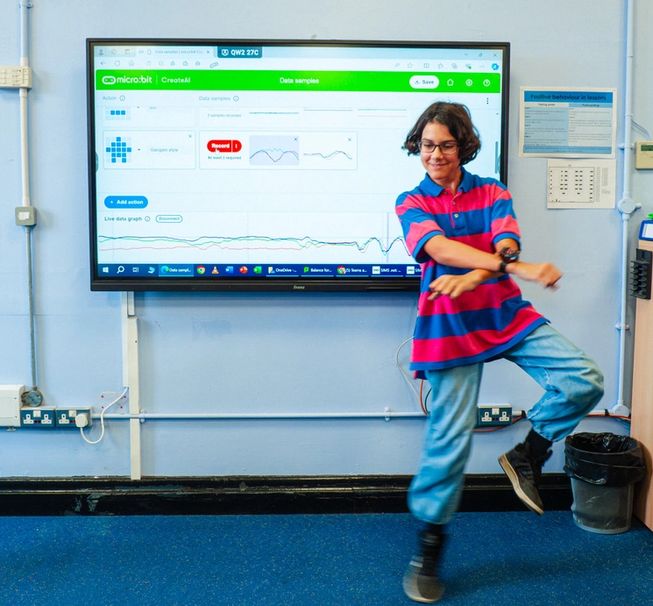 A student is dancing in front of the CreateAI page, as it measures the student's dancing data