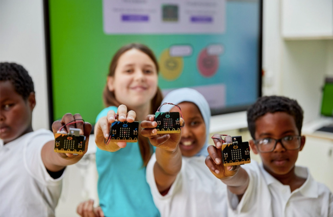 Four children holding up micro:bits