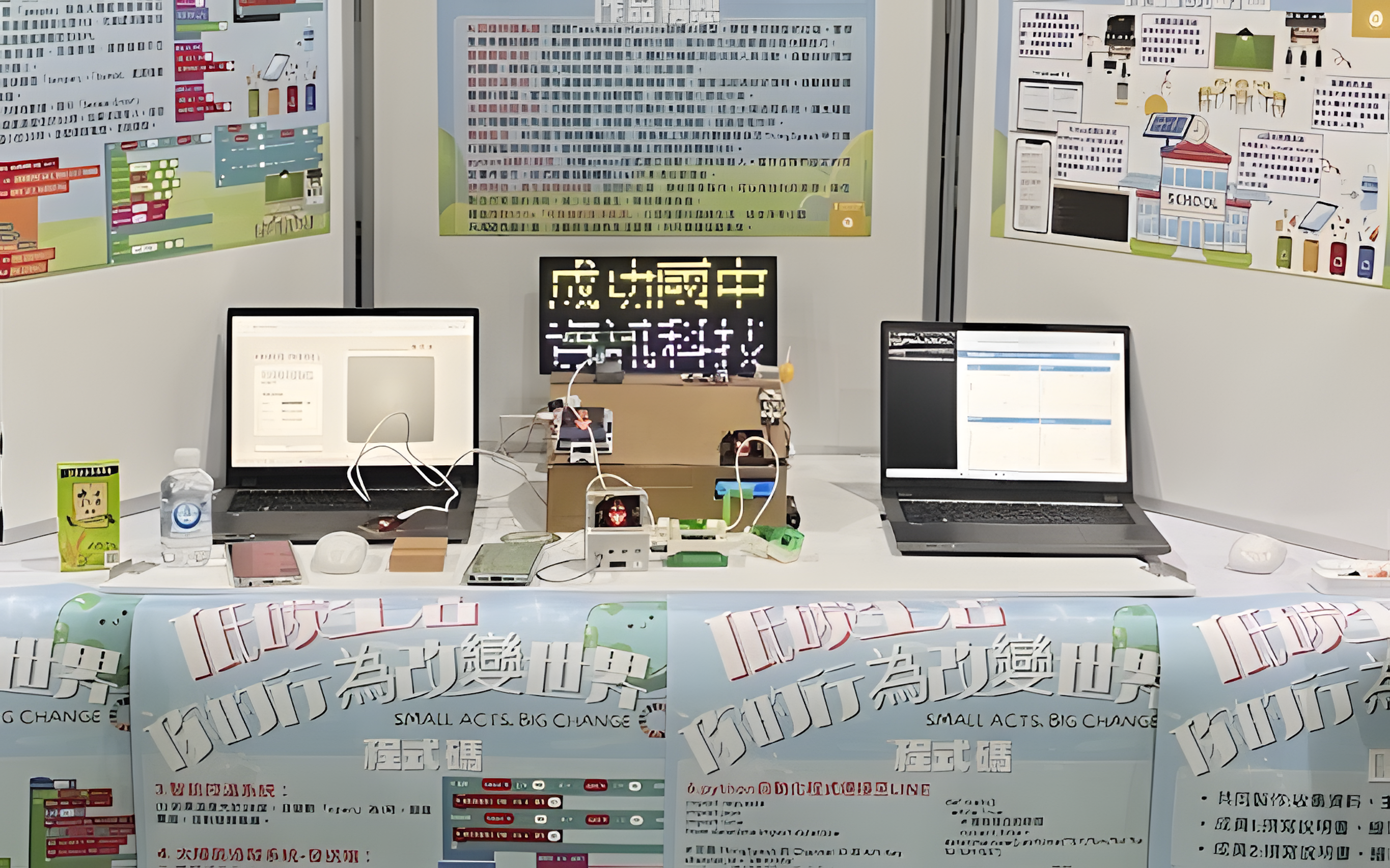 This picture shows two laptops connected to the project prototype sitting on a table in front of three posters describing the project.