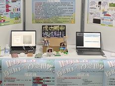 This picture shows two laptops connected to the project prototype sitting on a table in front of three posters describing the project.