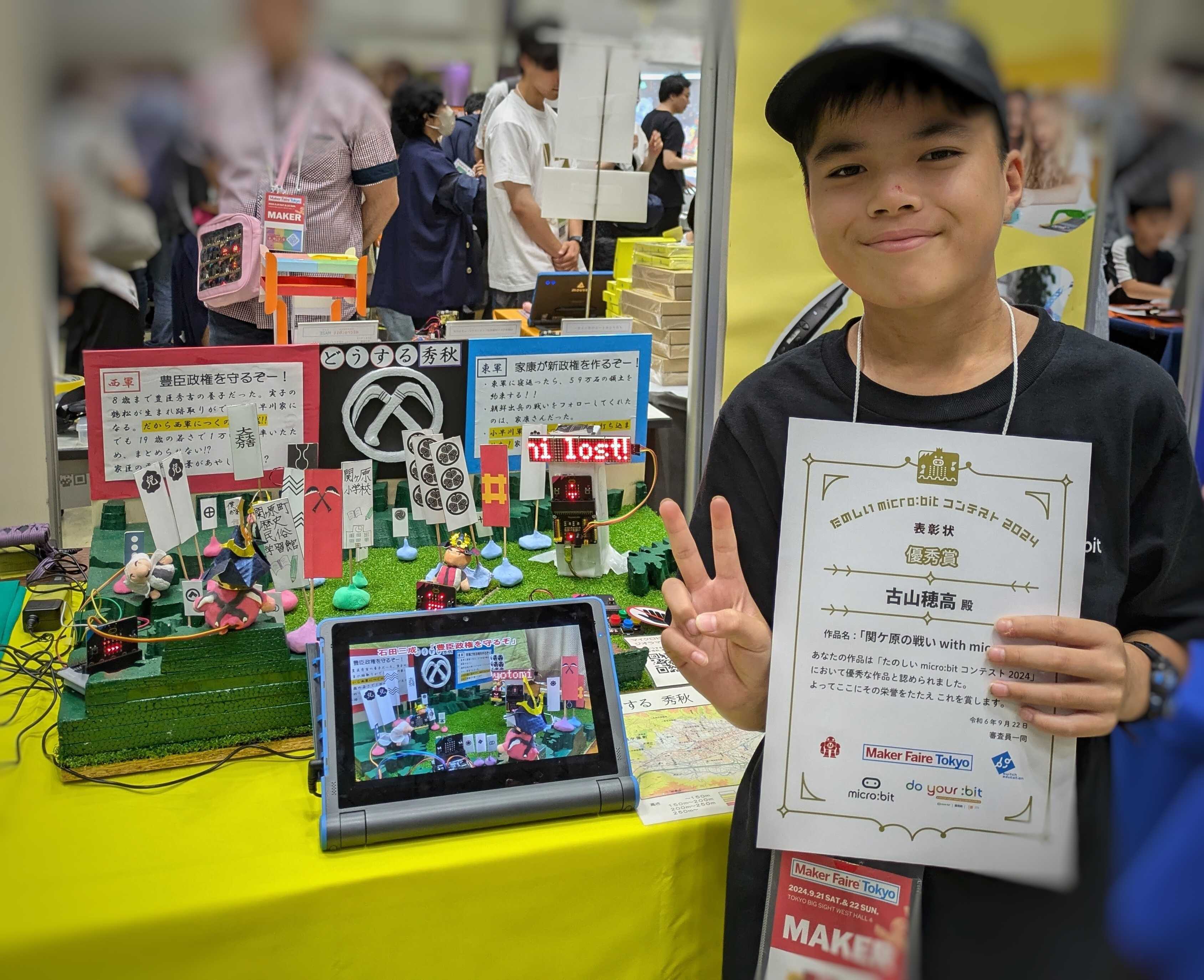 Student presenting the Battle of Sekigahara diorama and a certificate.