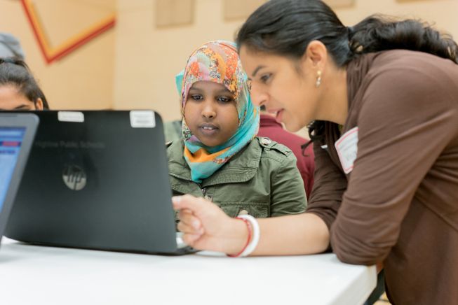 Teacher with student and laptop