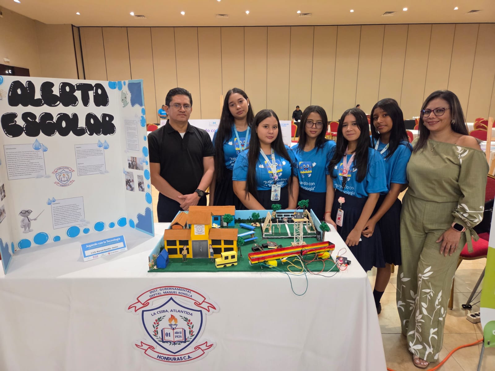 Students pose with their presentation poster and a prototype of their project.