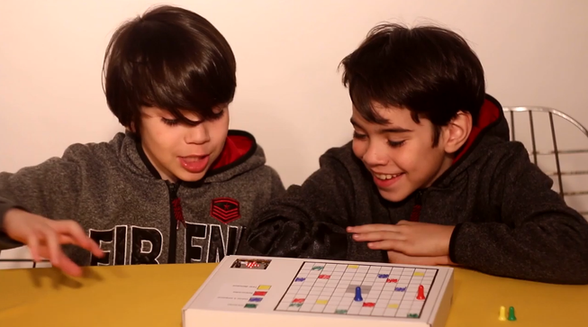 Two boys playing a board game with a micro:bit