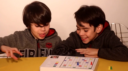 two boys playing a micro:bit Ludo game