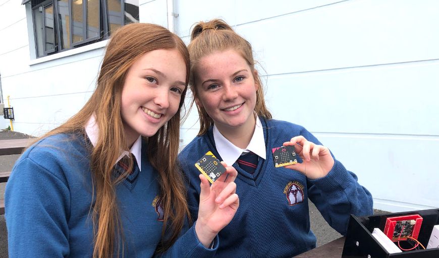 Two secondary school students holding micro:bits