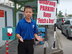 Student presents the Park Guard prototype near a parking area.