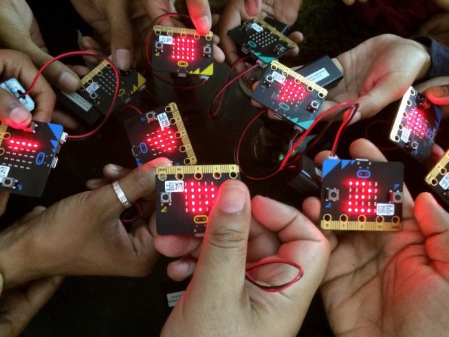 Up close picture of children holding micro:bits