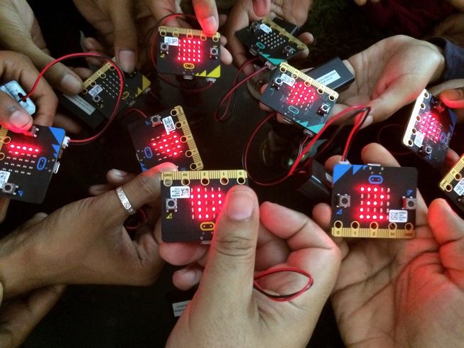 Up close picture of children holding micro:bits