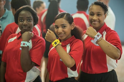 Three girls wearing micro:bit step counters