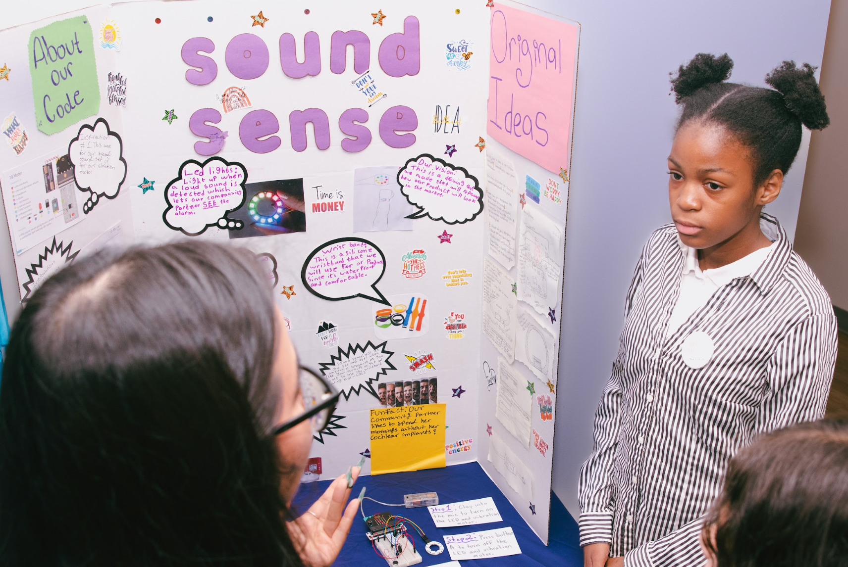 A student stands beside their project board.