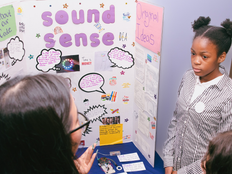 A student stands beside their project board.