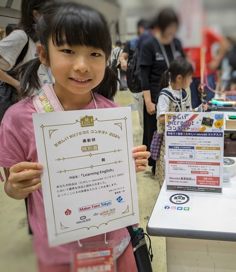 The student poses with her award for presenting the Learning English project.