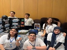 Students pose with their presentation poster and a prototype of their project.