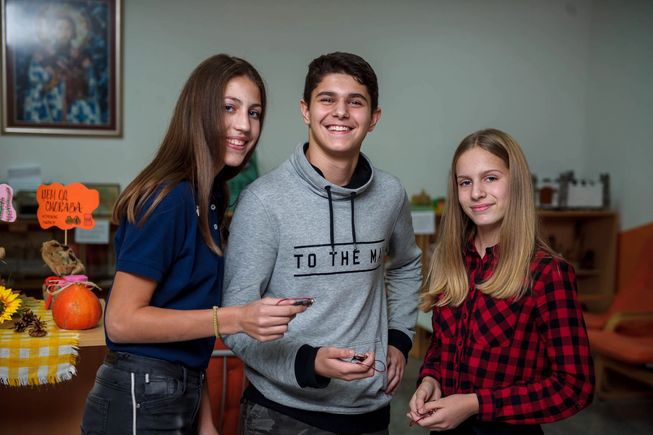 Three happy students holding micro:bits