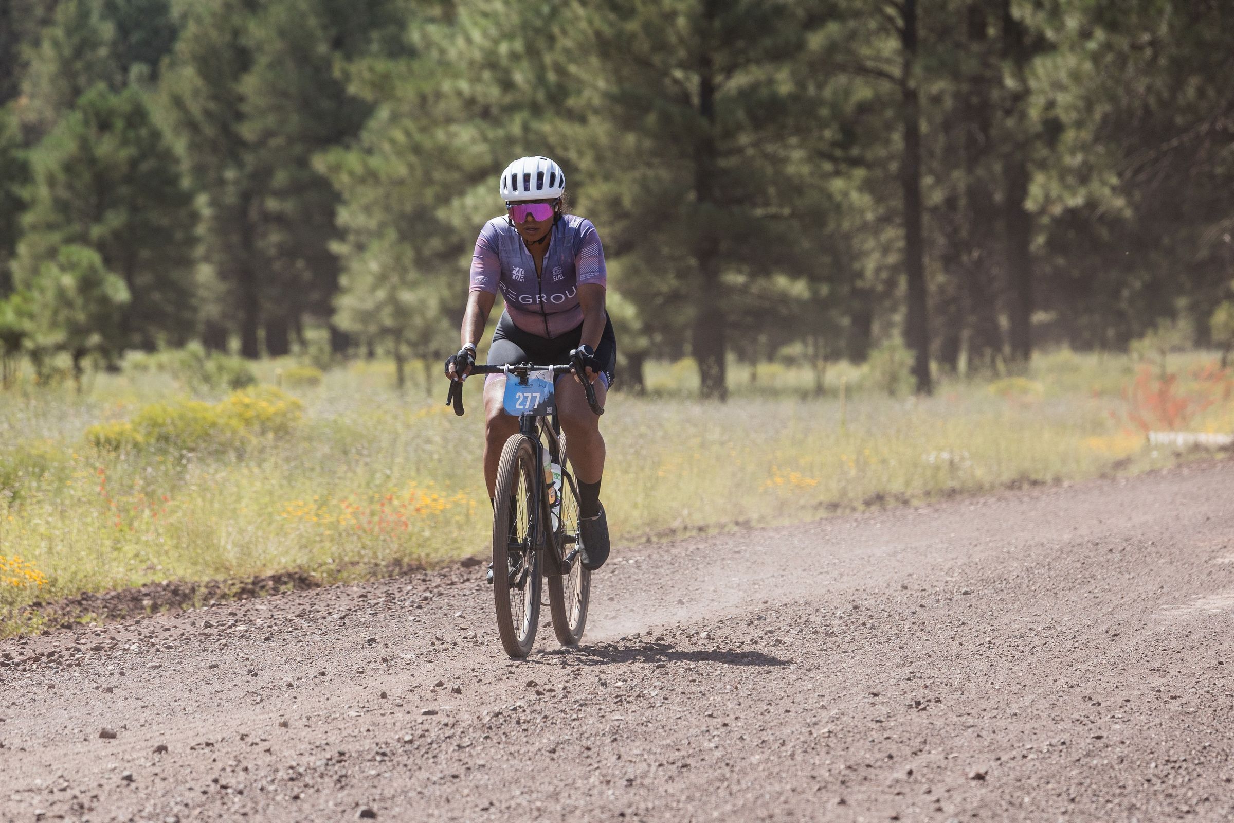 A rider on a gravel road through the pines at Village Gravel