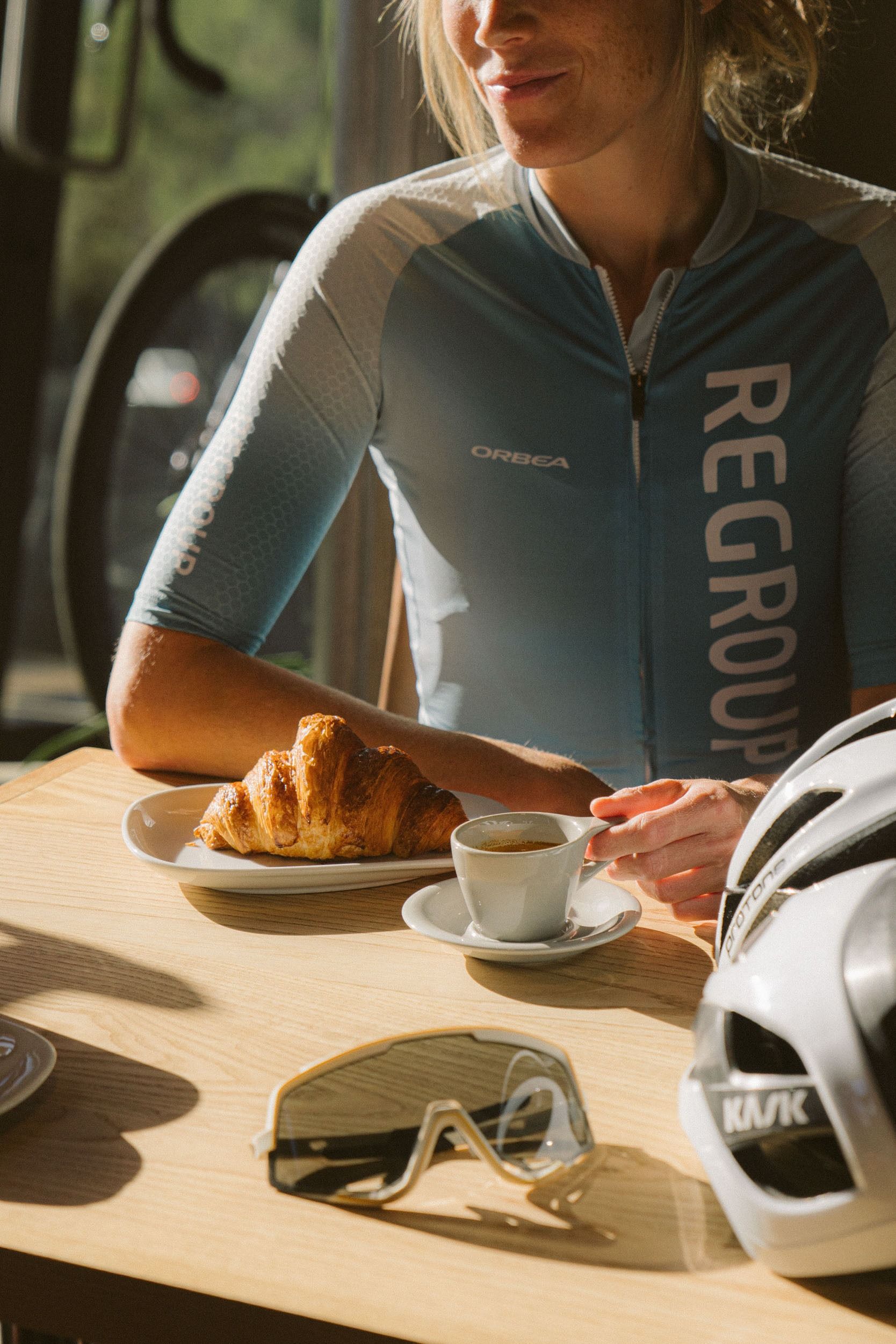 Espresso and a croissant at the café, helmet and glasses on the table