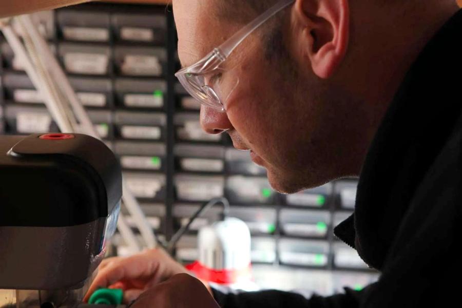 A Lock City locksmith cutting and programming a key in the workshop
