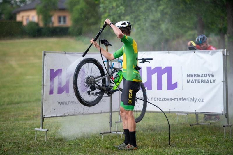 A rider lifts the bike overhead — MTB Maraton Chýnov 2026, photo Joggi foto