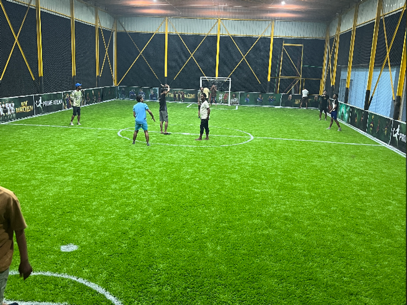 Action shot of football players competing for the ball during a match on the indoor
