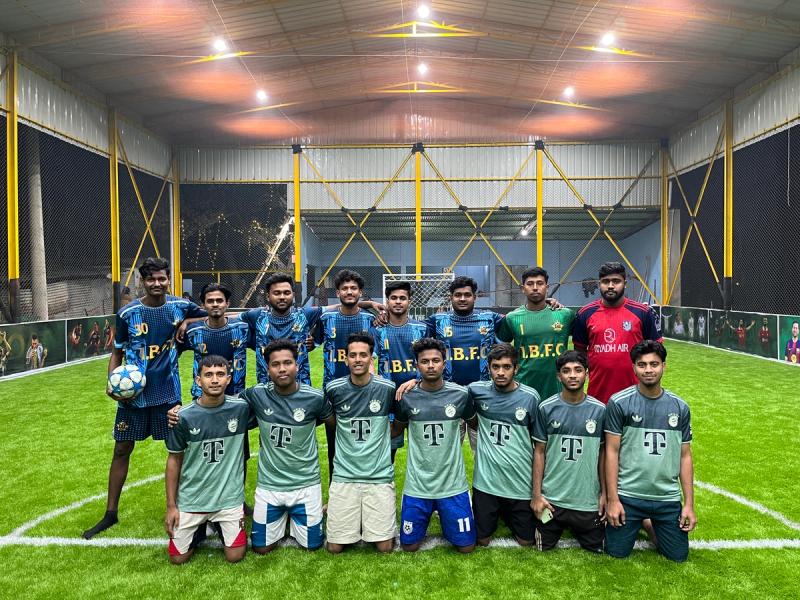 Players in blue jerseys celebrating a goal together on the football field