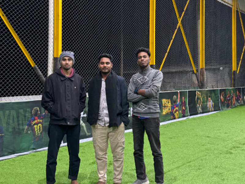 A close-up of a classic black and white football resting on the vibrant green artificial grass
