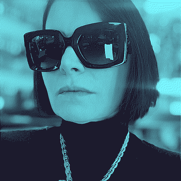 A (dithered, stylized) image of a stylish woman (Valeska O'Leary) wearing large sunglasses, a turtleneck, and a gold chain.