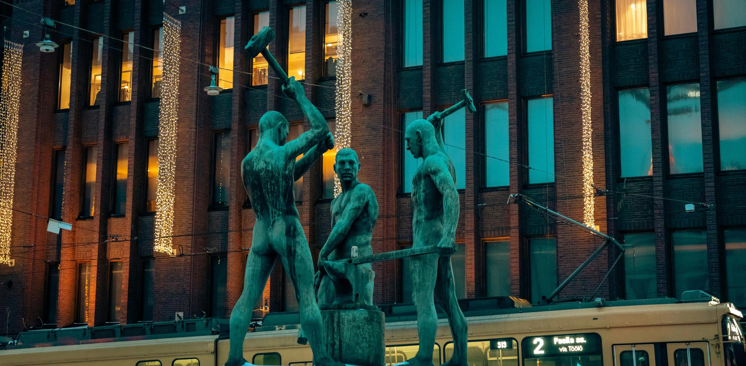 Памятник Kolmen sepän patsas в Хельсинки напротив универмага Стокманн