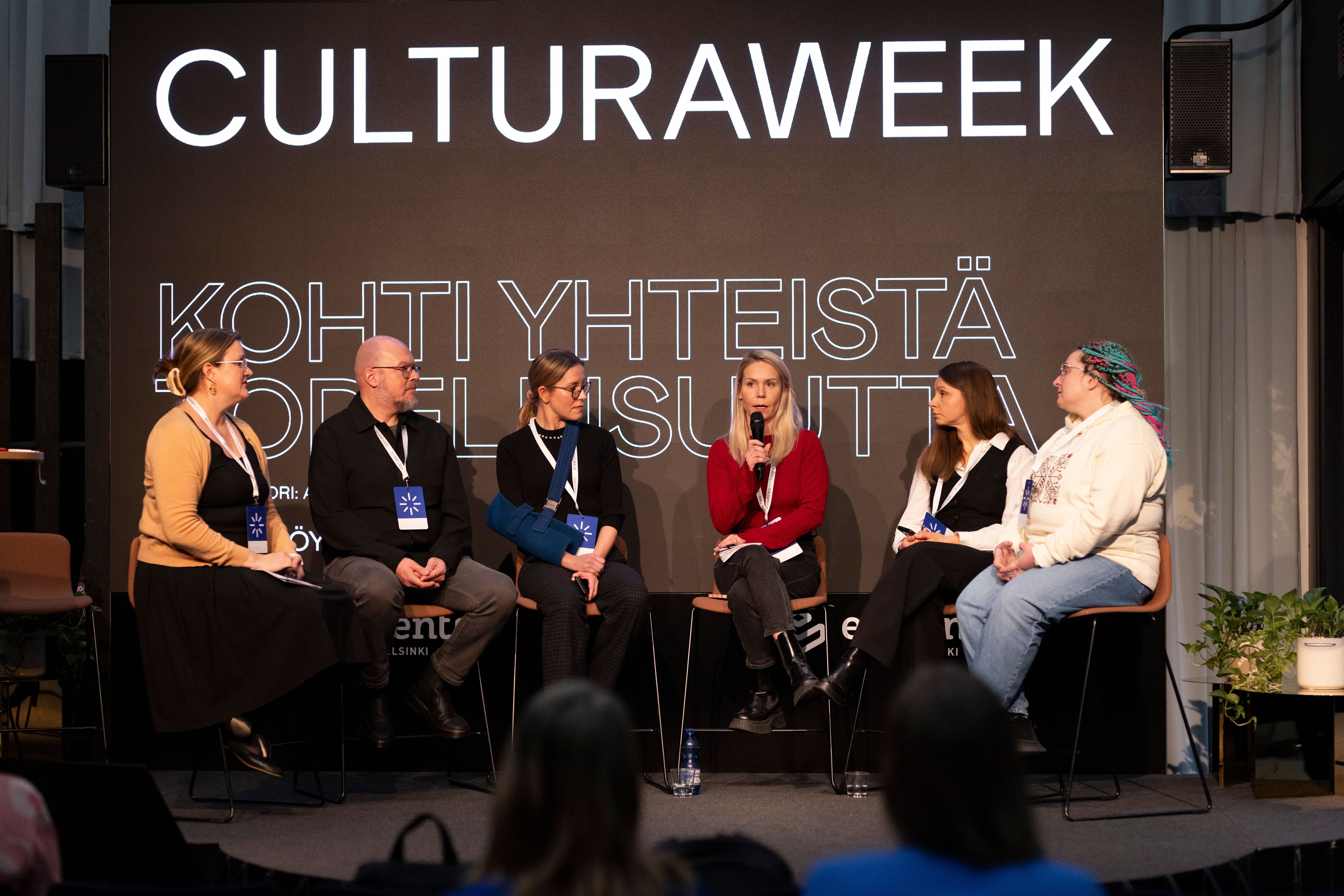 Kuusi panelistia konferenssissa keskustelemassa